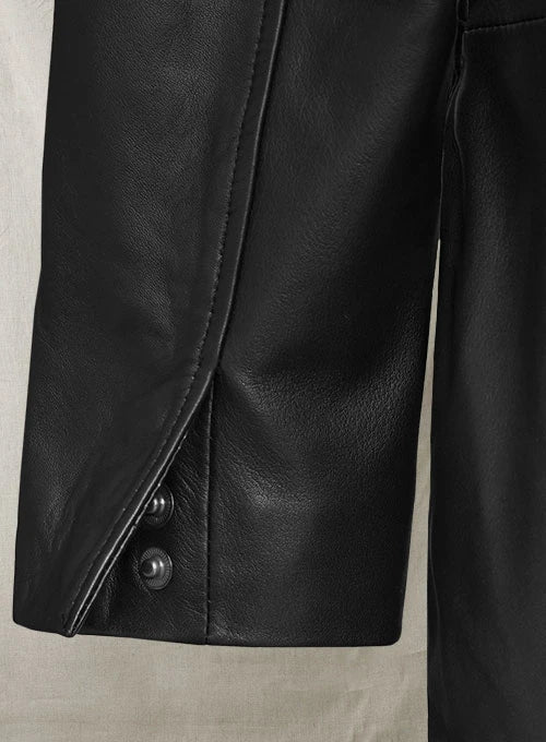 Close-up of a black leather jacket with a button on a neutral background