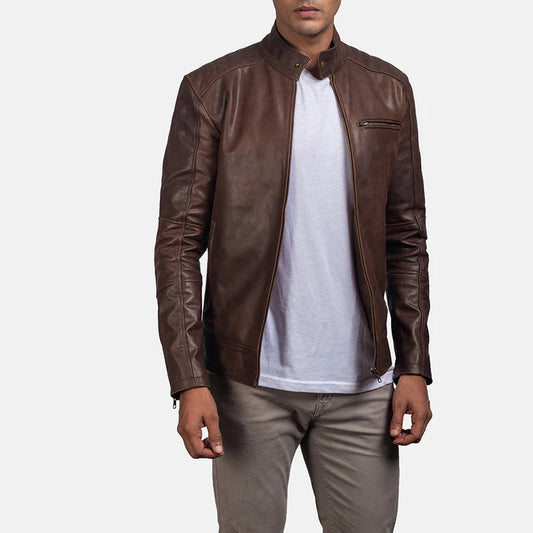 Man wearing a brown leather jacket over a white shirt on a light gray background