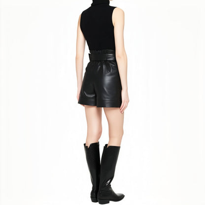 Woman wearing ZERXHIDE black leatherette shorts — back view styled with black turtleneck and knee-high boots